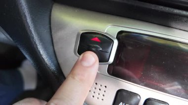 Analog araba düğmeleri. Klasik teypte parmak oynatma düğmesine basan adam. Aydınlatılırken klimayı devre dışı bırakmak için parmak kapatma düğmesine basın
