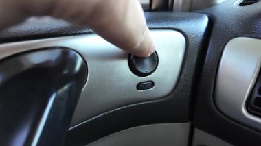 Analog araba düğmeleri. Klasik teypte parmak oynatma düğmesine basan adam. Aydınlatılırken klimayı devre dışı bırakmak için parmak kapatma düğmesine basın