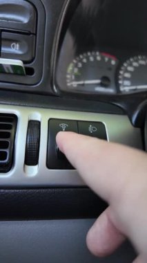 Analog araba düğmeleri. Klasik teypte parmak oynatma düğmesine basan adam. Aydınlatılırken klimayı devre dışı bırakmak için parmak kapatma düğmesine basın