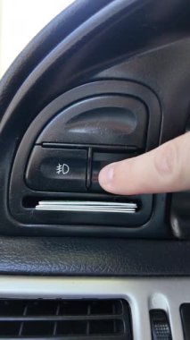 Analog araba düğmeleri. Klasik teypte parmak oynatma düğmesine basan adam. Aydınlatılırken klimayı devre dışı bırakmak için parmak kapatma düğmesine basın