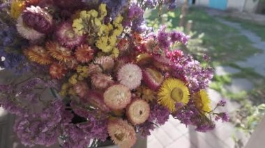 Parlak sonbahar çiçekleri. Kurumuş çiçekler. Duvarda kurumuş çiçek aranjmanı ve oda dekorunda zemin. Çiçeklerin arka planı değişiyor. Saha kurumuş iç organ.