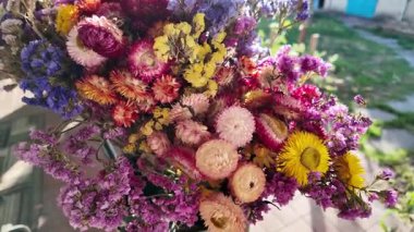 Parlak sonbahar çiçekleri. Kurumuş çiçekler. Duvarda kurumuş çiçek aranjmanı ve oda dekorunda zemin. Çiçeklerin arka planı değişiyor. Saha kurumuş iç organ.