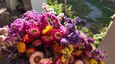 Parlak sonbahar çiçekleri. Kurumuş çiçekler. Duvarda kurumuş çiçek aranjmanı ve oda dekorunda zemin. Çiçeklerin arka planı değişiyor. Saha kurumuş iç organ.