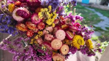 Parlak sonbahar çiçekleri. Kurumuş çiçekler. Duvarda kurumuş çiçek aranjmanı ve oda dekorunda zemin. Çiçeklerin arka planı değişiyor. Saha kurumuş iç organ.