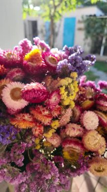 Parlak sonbahar çiçekleri. Kurumuş çiçekler. Duvarda kurumuş çiçek aranjmanı ve oda dekorunda zemin. Çiçeklerin arka planı değişiyor. Saha kurumuş iç organ.