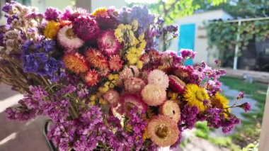 Parlak sonbahar çiçekleri. Kurumuş çiçekler. Duvarda kurumuş çiçek aranjmanı ve oda dekorunda zemin. Çiçeklerin arka planı değişiyor. Saha kurumuş iç organ.