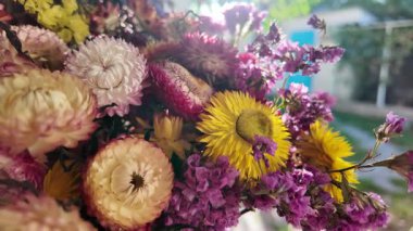 Parlak sonbahar çiçekleri. Kurumuş çiçekler. Duvarda kurumuş çiçek aranjmanı ve oda dekorunda zemin. Çiçeklerin arka planı değişiyor. Saha kurumuş iç organ.