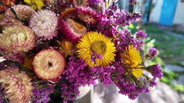 Parlak sonbahar çiçekleri. Kurumuş çiçekler. Duvarda kurumuş çiçek aranjmanı ve oda dekorunda zemin. Çiçeklerin arka planı değişiyor. Saha kurumuş iç organ.