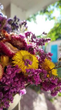 Parlak sonbahar çiçekleri. Kurumuş çiçekler. Duvarda kurumuş çiçek aranjmanı ve oda dekorunda zemin. Çiçeklerin arka planı değişiyor. Saha kurumuş iç organ.