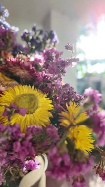 Parlak sonbahar çiçekleri. Kurumuş çiçekler. Duvarda kurumuş çiçek aranjmanı ve oda dekorunda zemin. Çiçeklerin arka planı değişiyor. Saha kurumuş iç organ.