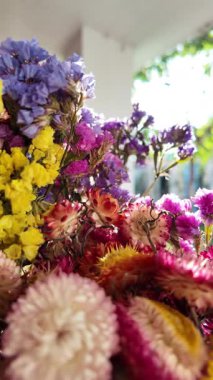 Parlak sonbahar çiçekleri. Kurumuş çiçekler. Duvarda kurumuş çiçek aranjmanı ve oda dekorunda zemin. Çiçeklerin arka planı değişiyor. Saha kurumuş iç organ.