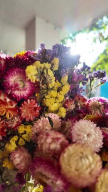 Parlak sonbahar çiçekleri. Kurumuş çiçekler. Duvarda kurumuş çiçek aranjmanı ve oda dekorunda zemin. Çiçeklerin arka planı değişiyor. Saha kurumuş iç organ.