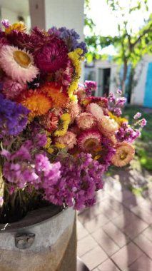 Parlak sonbahar çiçekleri. Kurumuş çiçekler. Duvarda kurumuş çiçek aranjmanı ve oda dekorunda zemin. Çiçeklerin arka planı değişiyor. Saha kurumuş iç organ.