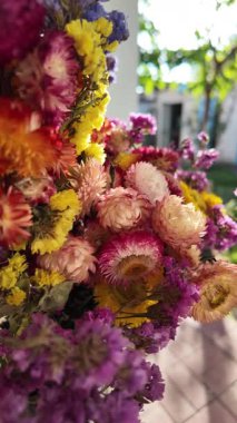 Parlak sonbahar çiçekleri. Kurumuş çiçekler. Duvarda kurumuş çiçek aranjmanı ve oda dekorunda zemin. Çiçeklerin arka planı değişiyor. Saha kurumuş iç organ.