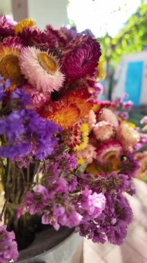 Parlak sonbahar çiçekleri. Kurumuş çiçekler. Duvarda kurumuş çiçek aranjmanı ve oda dekorunda zemin. Çiçeklerin arka planı değişiyor. Saha kurumuş iç organ.