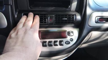 Arabada iklim kontrolü. Arabadaki analog aletler. Arabada iklim kontrolü. Bir adam kabinin düğmelerine basıyor. 4k video