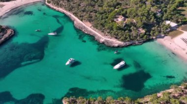 Mallorca 'da temiz turkuaz suyu olan bir körfezde demirleyen yatların hava görüntüsü. Akdeniz 'de. Mayorka 'da plaj