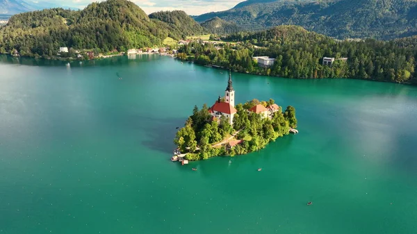 湖の上のマリア被昇天巡礼教会の周りを飛行する4Kの空中映像雲で美しい秋の日に祝福されました スロベニアのブレッド湖 — ストック写真