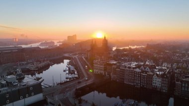 Amsterdam, Hollanda 'nın ünlü yerlerinin hava manzarası. Kanal ve eski merkez bölge manzarası. Tren istasyonu Amsterdam Centraal manzaralı gün doğumunda