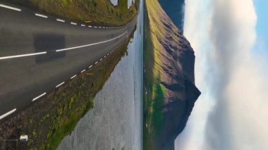 Driving a car in Iceland. Iceland road landscape with mountains around. Aerial vertical, vertical video background.