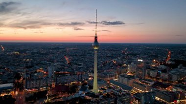 This aerial video showcases a vibrant cityscape with a majestic tower dominating the skyline. As the sun sets, warm colors illuminate the city, creating a captivating atmosphere clipart