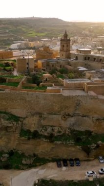 Tarihi Kale 'nin havadan dikey görüntüsü günbatımında vadiye tepeden bakan tepedeki Citadel Harabeleri' nin arka planı yemyeşil. Gozo adası. Malta