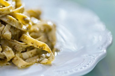 close up of plate of rustic italian basil pesto pasta