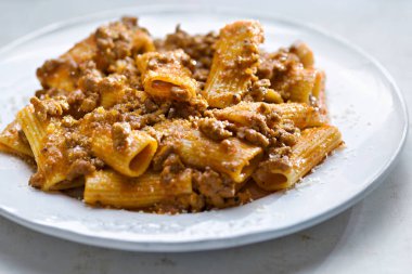 Bir tabak rigatoni bolonili makarnayı yakın.                         