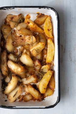 Bir tepsi kızarmış patates dilimini yakın.