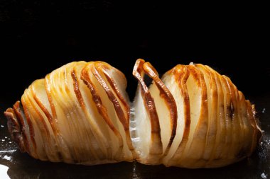 Bir tepsi rustik hasselback fırınlanmış patatesi yakın çekim