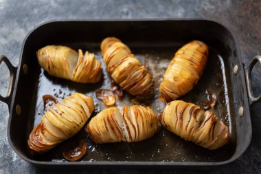 Bir tepsi rustik hasselback fırınlanmış patatesi yakın çekim