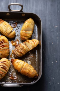 Bir tepsi rustik hasselback fırınlanmış patatesi yakın çekim
