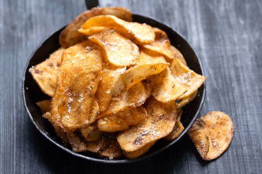 Bir tava dolusu kızarmış patates cipsinin yanına.