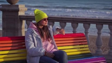 Girl on a bench painted in rainbow colors. High quality 4k footage