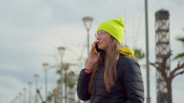 Girl Bright Hat Talking Phone Street Lanterns Weather Cloudy Cool — стокове відео