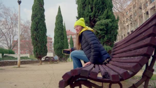 Girl Sits Park Bench Backdrop Cypresses Path Park Cool Weather — Stock video