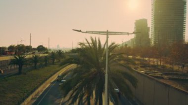 View of the track going through the city, sunset. Bright sunshine.