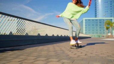 A girl rides a skateboard wagging. High quality 4k footage