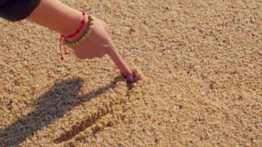 Hand draws heart on sand. High quality 4k footage