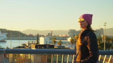 A girl with glasses walks along the yacht club. High quality 4k footage