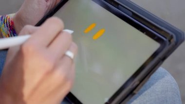 Bir kız tablete bir gülümseme çizer ve gülümseme kelimesini yazar. Yüksek kalite 4k görüntü