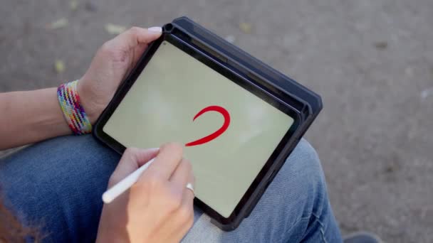 Das Mädchen Zeichnet Großaufnahme Ein Herz Auf Einem Tablet Hochwertiges — Stockvideo