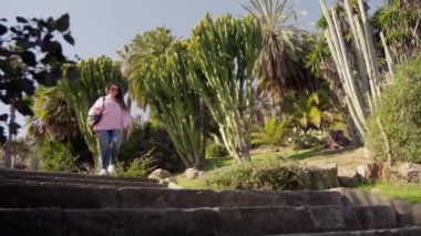 Bir kız parkta merdivenlerden aşağı iniyor. Yüksek kalite 4k görüntü