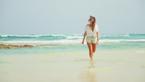 Dziewczyna Biegnie Wzdłuż Plaży Zbliża Się Biały Piasek Błękitne Morze — Wideo stockowe