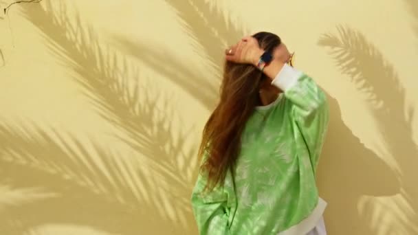 Egy Lány Sárga Falnál Pálmalevelek Árnyékával Kiváló Minőségű Felvételek — Stock videók