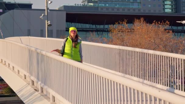 Ένα Κορίτσι Διασχίζει Μια Λευκή Γέφυρα Ηλιοβασίλεμα Υψηλής Ποιότητας Πλάνα — Αρχείο Βίντεο