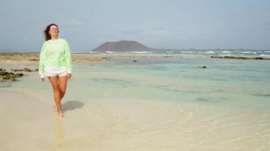 Kız suda yürüyor, saçları rüzgarda gelişiyor. Yüksek kalite 4k görüntü