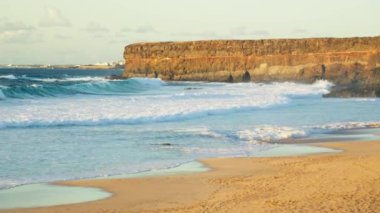 Gün batımında kayalık sahil, büyük dalgalar, Fuerteventura Adası. Yüksek kalite 4k görüntü