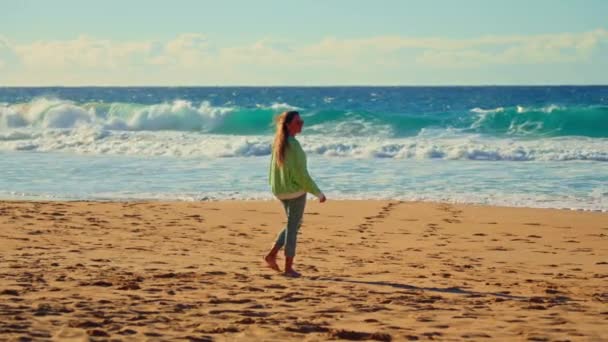 女孩在波浪 汹涌的大海和日落的背景下走着 高质量的4K镜头 — 图库视频影像