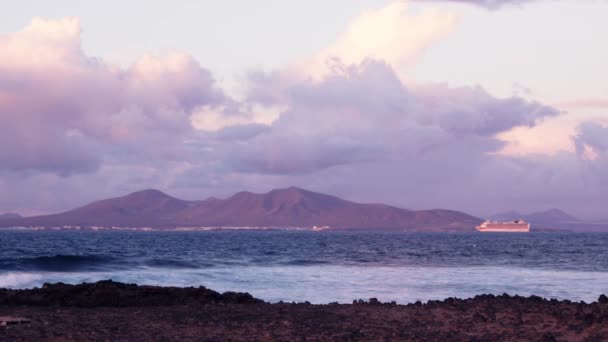 Хвилі Падають Кам Яний Берег Відстані Видно Силует Вулканічного Острова — стокове відео